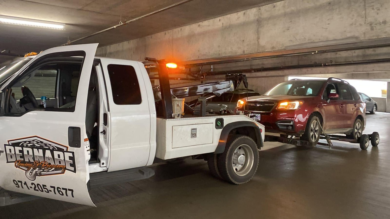 Bernabe Towing wheel lift transporting Cadillac vehicle